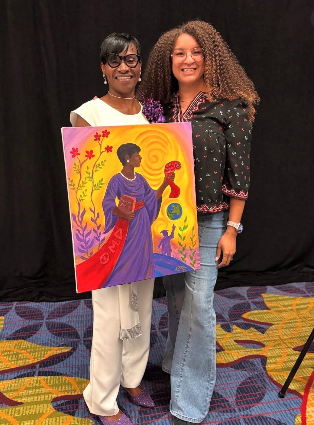Reinilda holding a finished live painting alongside a guest